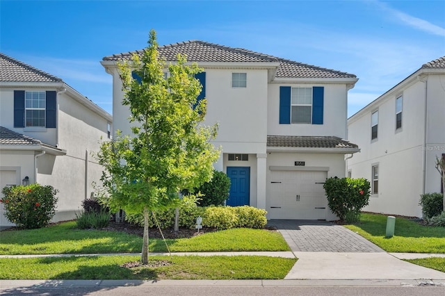 mediterranean / spanish house with a front lawn and a garage