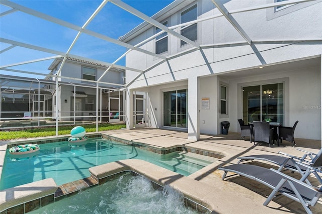 view of pool featuring an in ground hot tub, glass enclosure, and a patio