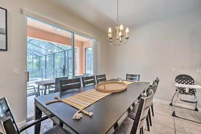 tiled dining room featuring a notable chandelier and a healthy amount of sunlight