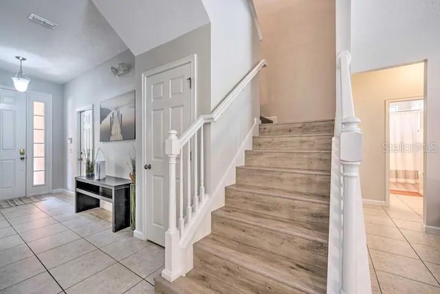 staircase featuring light tile flooring