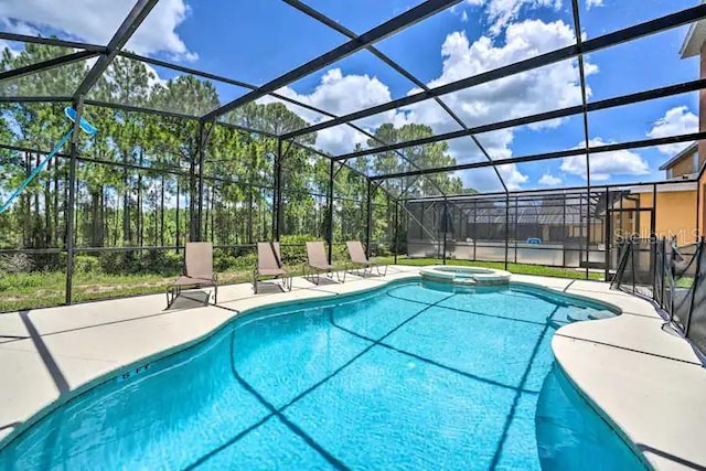 view of swimming pool featuring a patio area, an in ground hot tub, and a lanai