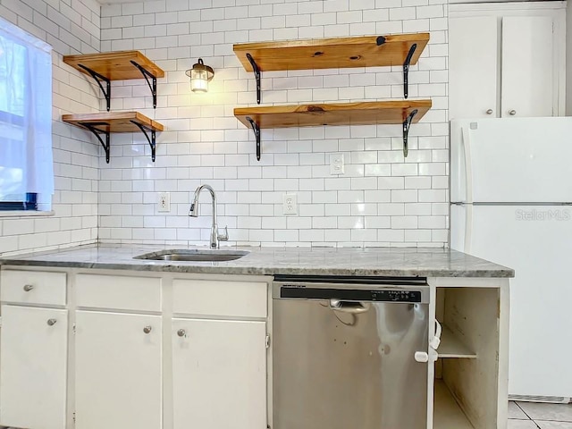 kitchen with white refrigerator, white cabinetry, dishwasher, and sink