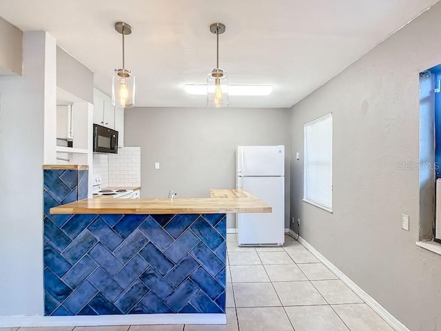 kitchen featuring white appliances, pendant lighting, light tile flooring, tasteful backsplash, and white cabinetry