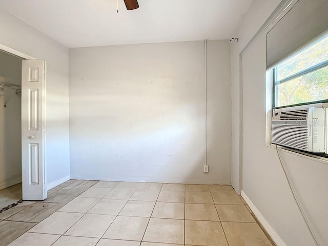 tiled spare room featuring ceiling fan