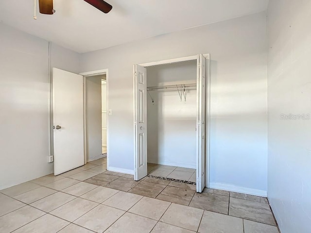 unfurnished bedroom with a closet, ceiling fan, and light tile floors