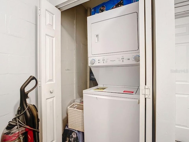 clothes washing area with stacked washer / dryer