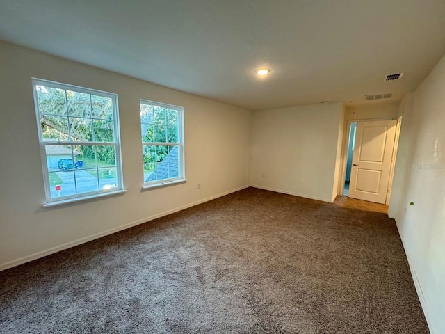 spare room with dark carpet