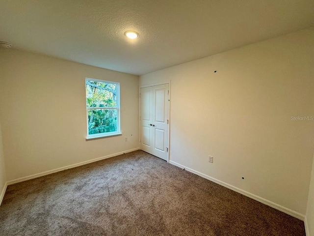 empty room with carpet flooring and a textured ceiling