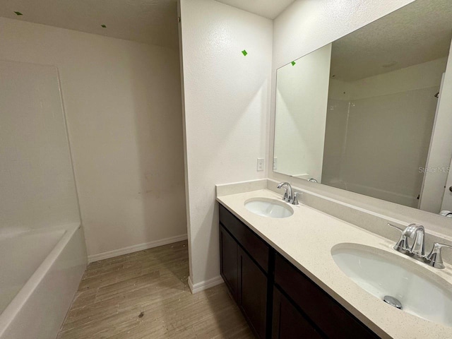 bathroom featuring hardwood / wood-style flooring, vanity, and a bathtub