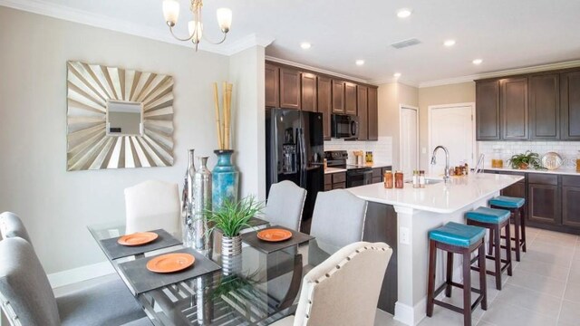 kitchen featuring sink, a breakfast bar area, ornamental molding, black appliances, and dark brown cabinets