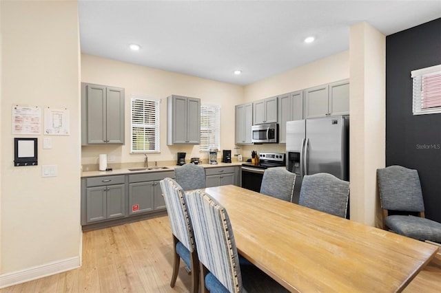 dining area with light wood-type flooring and sink