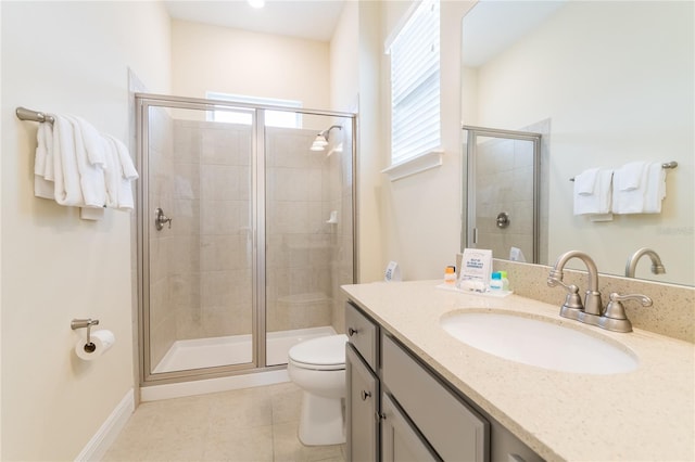 bathroom with tile flooring, a shower with shower door, vanity with extensive cabinet space, and toilet