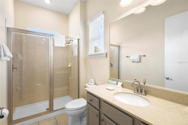 bathroom featuring a shower with door, tile flooring, toilet, and oversized vanity