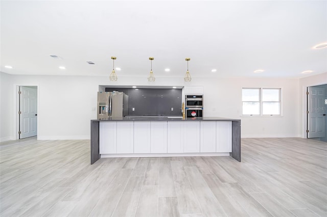 kitchen with white cabinetry, light hardwood / wood-style floors, stainless steel appliances, and pendant lighting