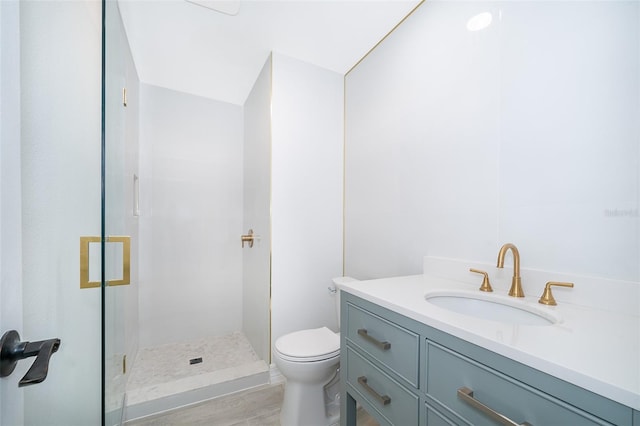 bathroom featuring toilet, a tile shower, and vanity