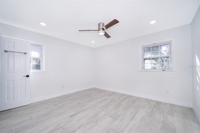 spare room with ceiling fan and light wood-type flooring