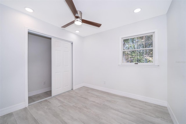 unfurnished bedroom with light hardwood / wood-style flooring, a closet, and ceiling fan