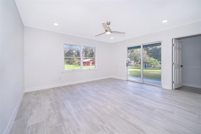 unfurnished room with ceiling fan, light wood-type flooring, and a wealth of natural light