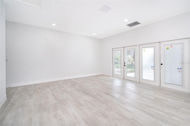 unfurnished room with light wood-type flooring and french doors