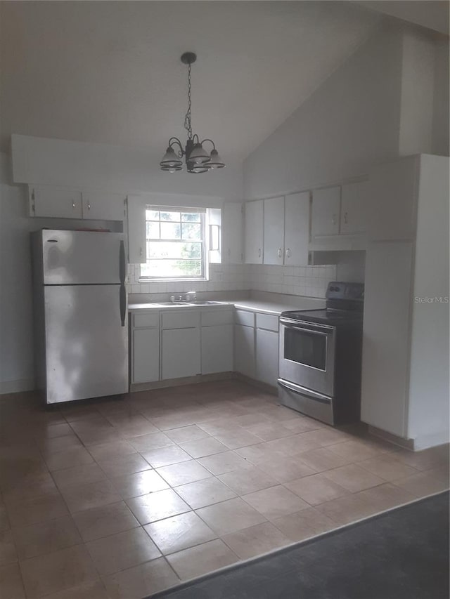 kitchen featuring light tile flooring, tasteful backsplash, white refrigerator, stainless steel range with electric stovetop, and a chandelier