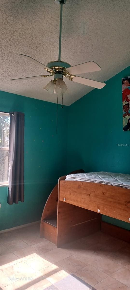 unfurnished bedroom featuring tile flooring and ceiling fan