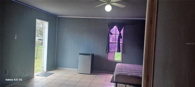 interior space featuring ceiling fan, light tile floors, and ornamental molding