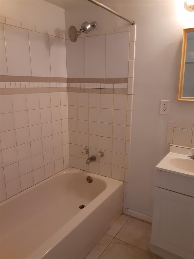 bathroom featuring vanity with extensive cabinet space, tiled shower / bath, and tile floors