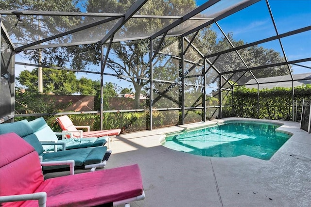 view of pool with a patio area and glass enclosure