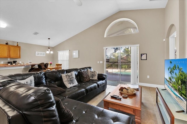 living room with high vaulted ceiling, a notable chandelier, and light tile floors