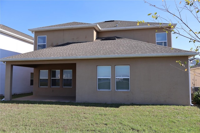 rear view of property featuring a yard and a patio area