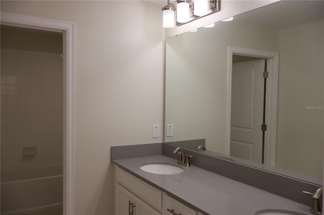 bathroom featuring tiled shower / bath combo and large vanity