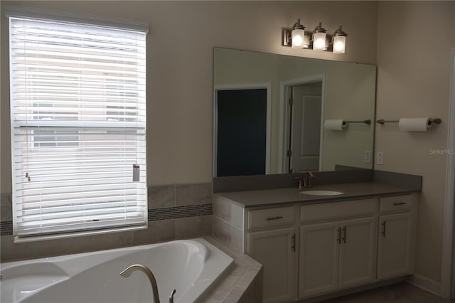 bathroom featuring vanity and tiled bath