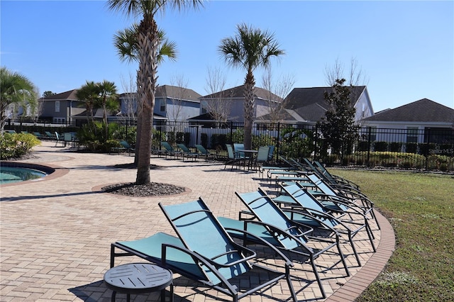 view of property's community with a swimming pool, a lawn, and a patio