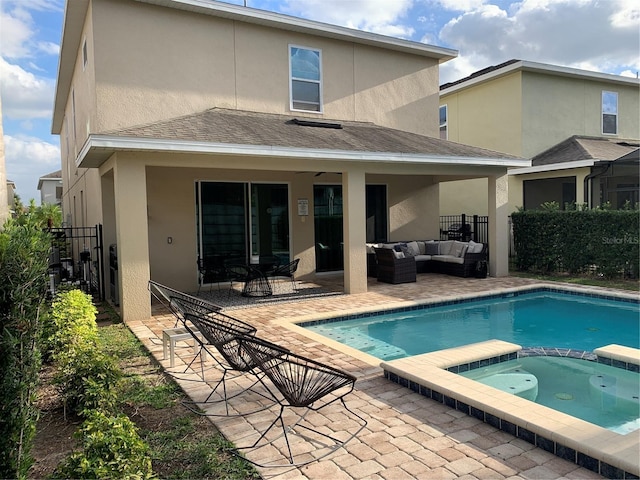 rear view of house with a swimming pool with hot tub, outdoor lounge area, and a patio