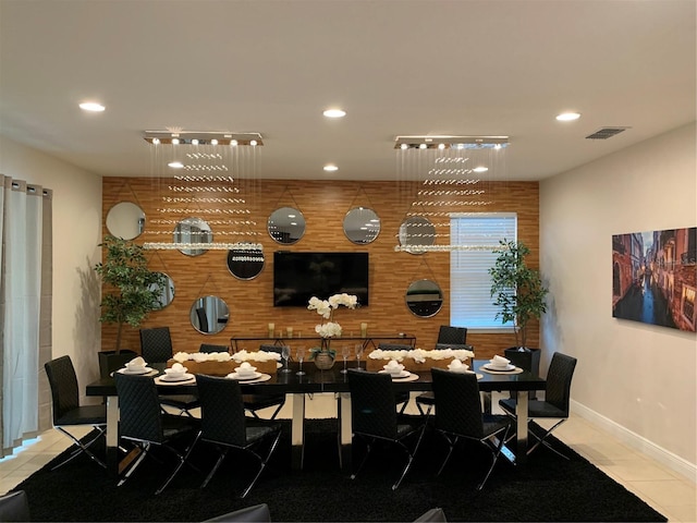 tiled dining space featuring wood walls