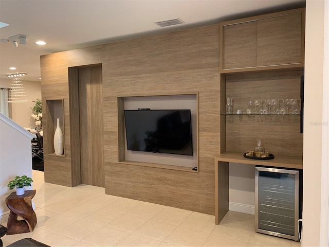 interior space with beverage cooler, bar area, and light tile patterned flooring