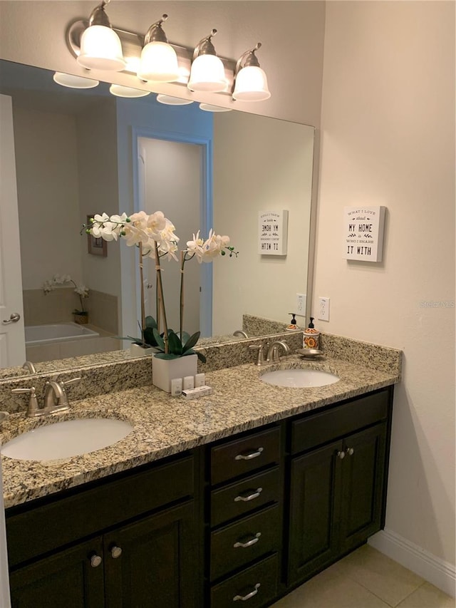 bathroom featuring dual vanity, a bathtub, and tile patterned floors