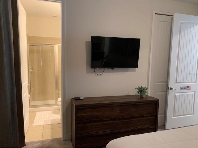 bedroom featuring ensuite bathroom and light tile patterned flooring