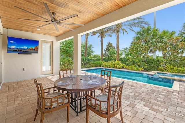 view of swimming pool with a patio, ceiling fan, and an in ground hot tub