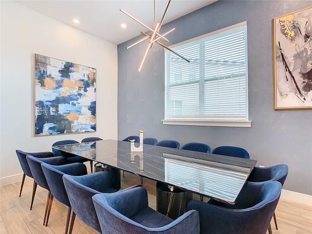 dining area with light hardwood / wood-style floors and a chandelier