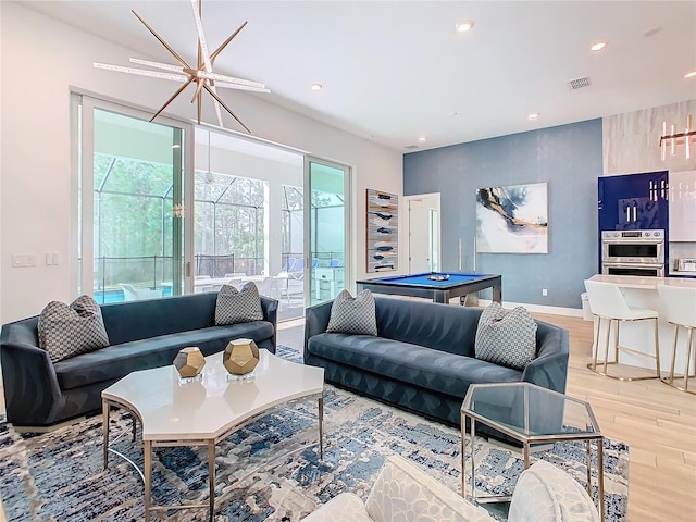 living room with pool table and light hardwood / wood-style floors