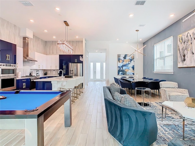 rec room featuring pool table, sink, and light hardwood / wood-style flooring