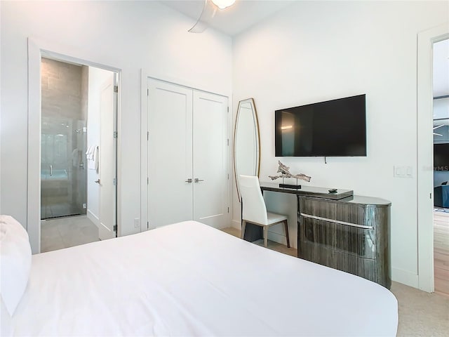 bedroom featuring light carpet, connected bathroom, a closet, and ceiling fan