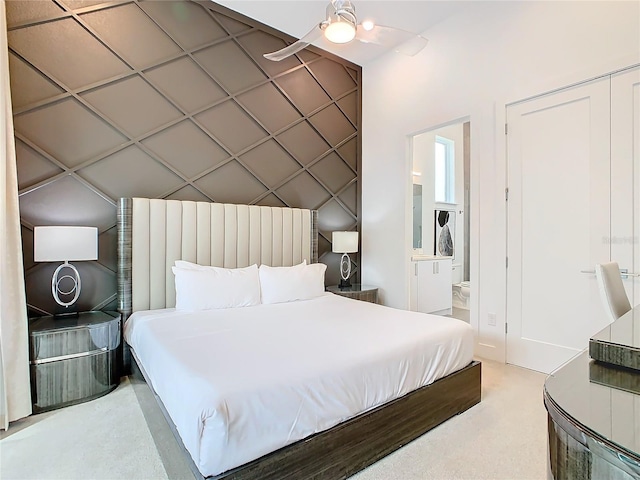 carpeted bedroom featuring a closet, ceiling fan, and ensuite bathroom