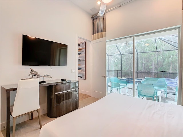 bedroom featuring access to exterior, ceiling fan, and a high ceiling