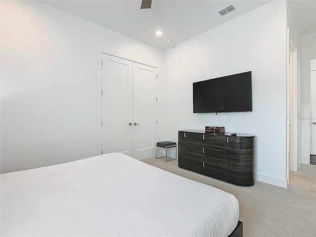 carpeted bedroom featuring a closet and ceiling fan