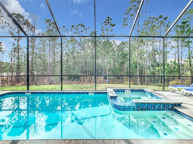 view of swimming pool with an in ground hot tub and a lanai