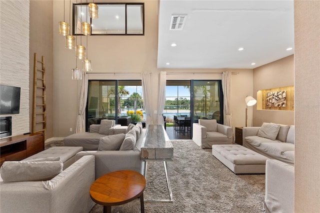 living room featuring a fireplace and a towering ceiling