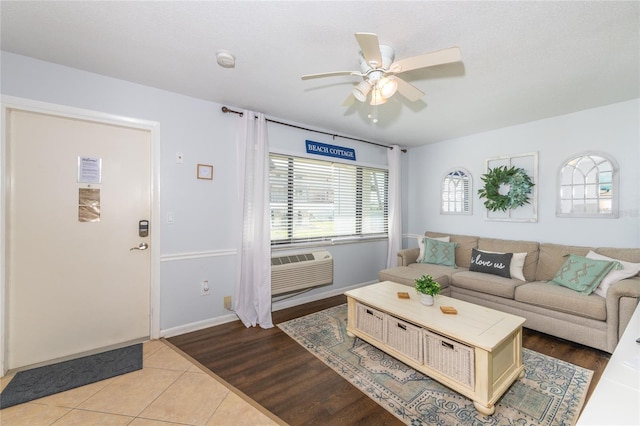 living room featuring light hardwood / wood-style flooring, a wall mounted air conditioner, and ceiling fan