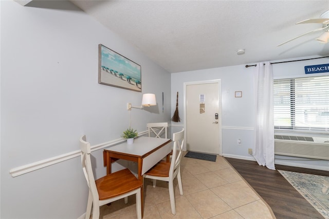 dining room featuring light hardwood / wood-style flooring, ceiling fan, and a textured ceiling